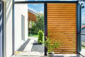 ueberdachung terrasse mit gelaender und lamellen sichtschutz alu in holzoptik detailansicht