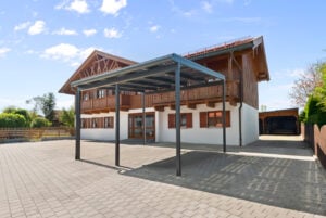 Moderner Solar Doppel-Carport von Leeb in gelungener Symbiose mit rustikalem Haus